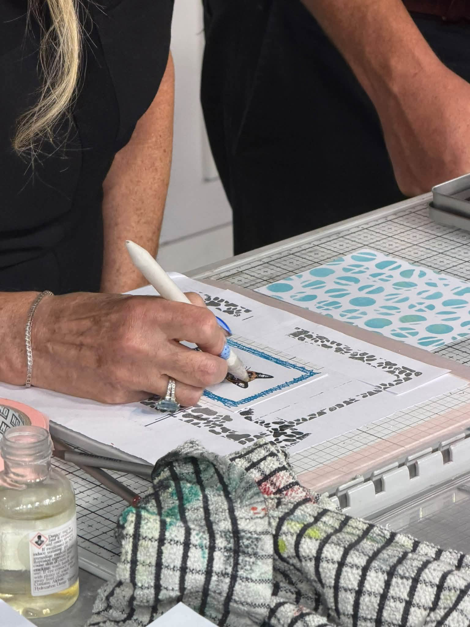 Karen adding colour to a stamped cat image with a blue border